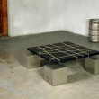 Tavolo basso 80X80 cm. Struttura in acciaio e piano in legno nero con inserti in resina scavati.