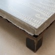 Tavolo basso 100X100 cm. Struttura in ferro grezzo tagliata al cannello e piano in cemento con inserti decorativi geometrici.